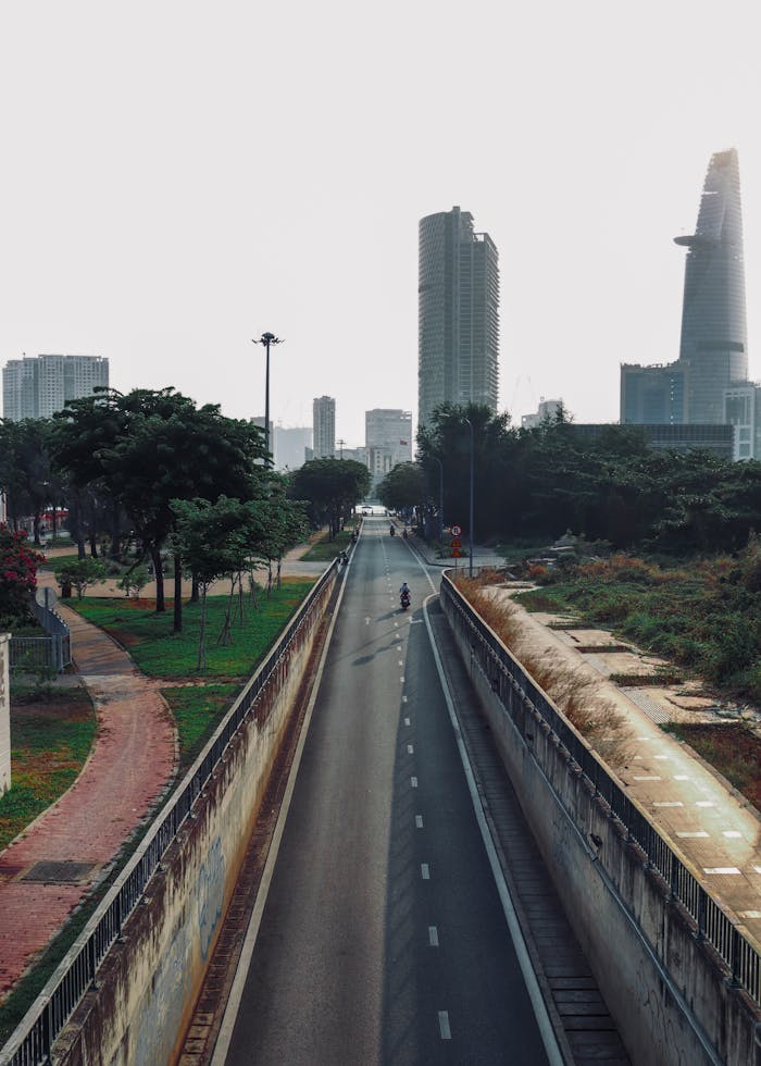 Home Quiet urban roadway lined with skyscrapers in the distance, reflecting a modern city vibe.